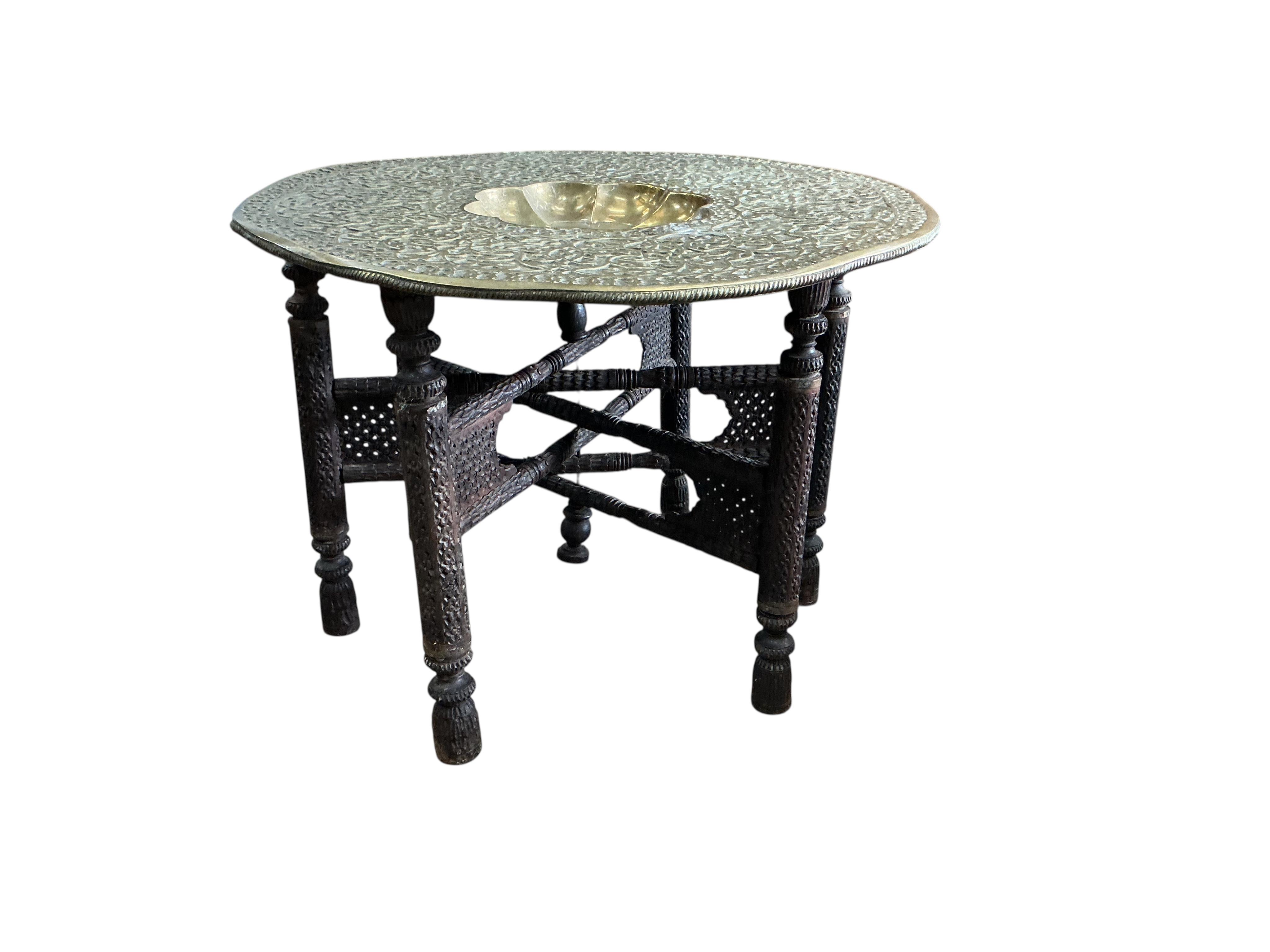 A brass tray top table on folding hardwood stand, diameter 76cm, height 57cm